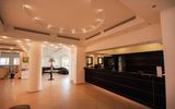 Moderne Hotel-Lobby mit stilvoller Rezeption, gemütlichen Sitzgelegenheiten und eleganter Beleuchtung – ein einladender Ort für den Empfang und entspannte Momente nach der Ankunft.