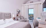 Helles, modern eingerichtetes Zimmer mit gemütlichem Bett, Sitzecke und Balkon – mit traumhaftem Blick auf das Meer und Palmen.