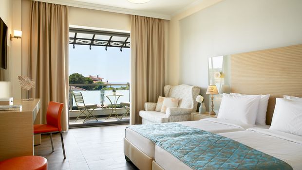 Stilvolles Doppelzimmer mit Balkon und gemütlicher Sitzecke – ideal für erholsame Urlaubstage.