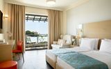 Stilvolles Doppelzimmer mit Balkon und gemütlicher Sitzecke – ideal für erholsame Urlaubstage.