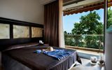 Komfortables Doppelzimmer mit elegantem Design und Zugang zum Balkon – genießen Sie entspannte Stunden mit Blick ins Grüne.